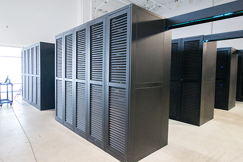 Rows of black louvred server cabinets on the sealed concrete floor inside eSecureData DC3