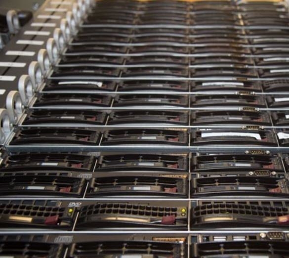 A close view of rackmount servers stacked several units deep, their front panels showing drive bays and optical drives